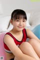 A young girl sitting on a pink exercise ball.